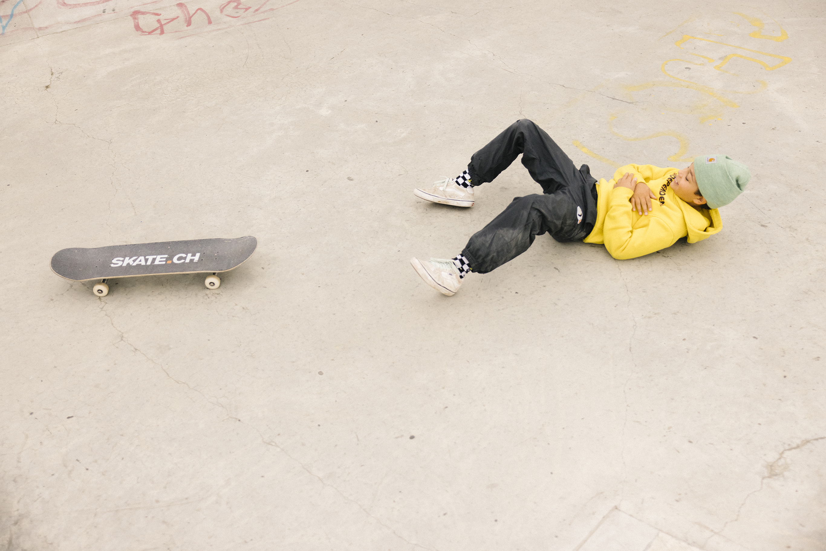 A young person lies on his back holding his arms together on his stomach.